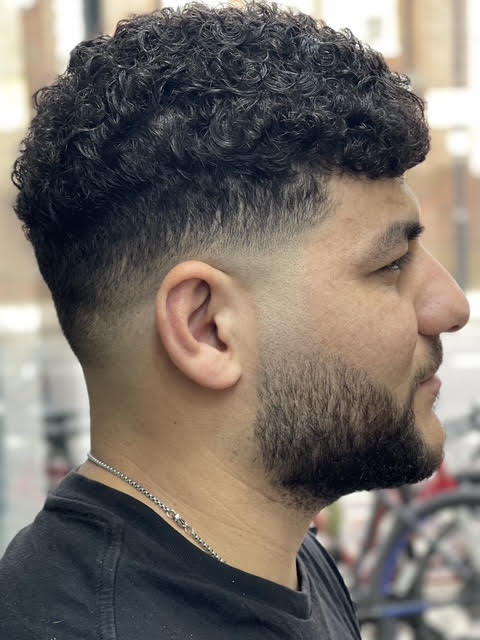 Drop fade on curly hair with a shaped beard